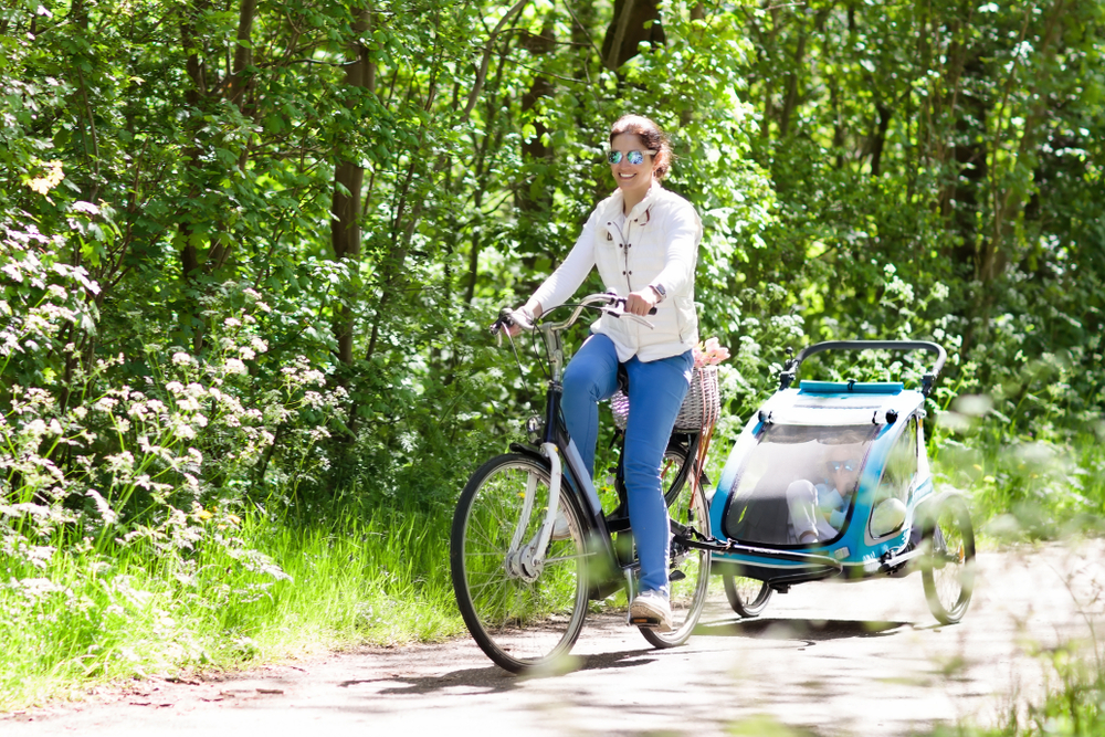 žena na bicykli s cyklovozíkom